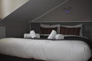 a large white bed with white towels on it at Alensgrove Maisonette D in Leixlip
