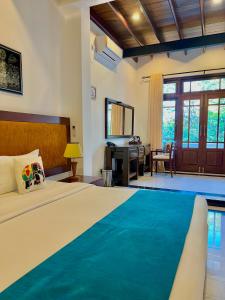 a bedroom with a large bed and a desk at The Grand Hanthana in Kandy
