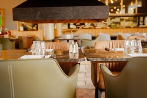 a restaurant with wooden tables and chairs with glasses on them at Hotel U Catagnu in San-Nicolao