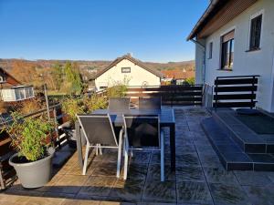eine Terrasse mit Tisch und Stühlen auf einem Balkon in der Unterkunft Panoramablick Eitelborn in Eitelborn
