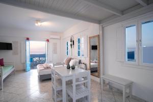 a living room with white furniture and a view of the ocean at Salvatore Caldera Suites in Imerovigli
