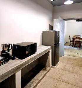 a kitchen with a microwave and a refrigerator at Gate House Mirissa in Mirissa