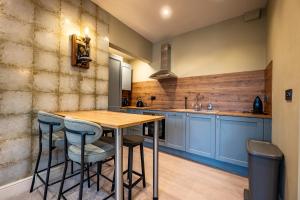 a kitchen with a wooden table and blue cabinets at The Links Apartments in Newark-on-Trent