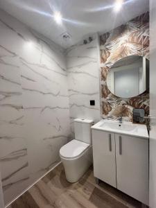 a bathroom with a white toilet and a sink at Abacoa Life in Alicante