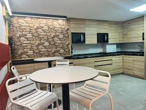 a kitchen with two tables and chairs and a stone wall at Abacoa Life in Alicante