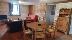 a living room with a table and a couch at La Tanière in Sirod