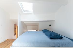 a bedroom with a bed with blue sheets and a window at Petit Emba in La Ciotat