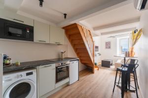 a kitchen with a washer and dryer and a staircase at Petit Emba in La Ciotat
