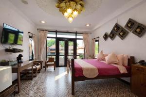 a bedroom with a bed and a desk and a television at Pludhaya Resort & Spa in Phra Nakhon Si Ayutthaya
