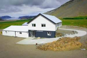 un grande edificio bianco con una montagna sullo sfondo di Glacier World - Hoffell Guesthouse a Hoffell