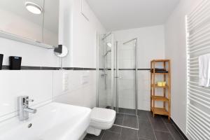 a bathroom with a toilet and a sink and a shower at Ferienwohnung Oberdeck in Juliusruh