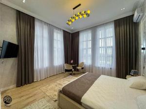 a bedroom with a large bed and a desk and windows at River Hotel Restaurant in Quba