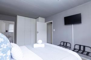 a bedroom with a bed with a television on the wall at 14 Madison Palms East in Johannesburg
