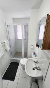 a white bathroom with a shower and a sink at 14 Madison Palms East in Johannesburg +5 photos