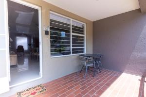 a porch with a table and a window and a table at 14 Madison Palms East in Johannesburg