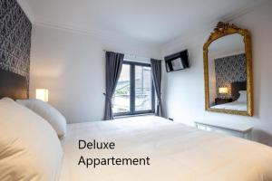 a bedroom with a large bed and a mirror at Apartlogie in Tongeren