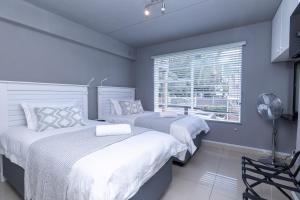 a bedroom with two beds and a window at 14 Madison Palms East in Johannesburg