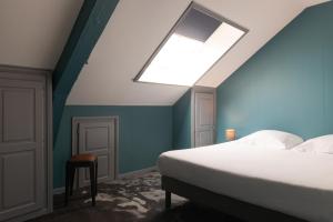 a bedroom with a bed and a skylight at Hôtel Bristol Reims in Reims +18 photos
