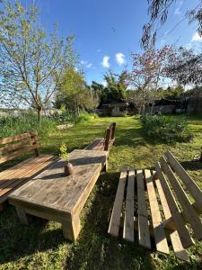 two wooden benches sitting on the grass in a park at הקרוואן במושב בורגתה in Burgeta