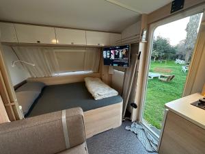 an rv with a couch and a tv in it at הקרוואן במושב בורגתה in Burgeta