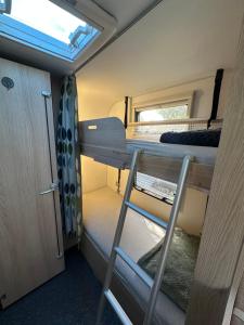 a small room with a bunk bed and a window at הקרוואן במושב בורגתה in Burgeta