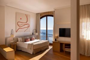 a bedroom with a bed and a view of the ocean at Parador de Ibiza in Ibiza Town