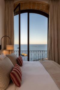 a bedroom with a bed with a view of the ocean at Parador de Ibiza in Ibiza Town +174 photos