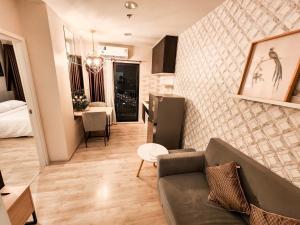 a living room with a couch and a dining room at Comfy Plum West Gate Condo 1 BR in Ban Bang Krabu +10 photos
