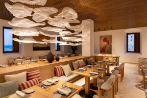 a restaurant with tables and chairs and a large chandelier at Parador de Ibiza in Ibiza Town