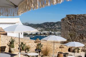 a patio with umbrellas and a view of a harbor at Parador de Ibiza in Ibiza Town