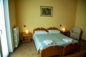sypialnia z dużym łóżkiem i 2 krzesłami w obiekcie Sporting Club w mieście Ballabio