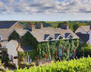 a house with ivy on the side of it at Ty Melin in Pembroke Dock