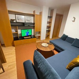 a living room with a blue couch and a television at Chalet Milanovic in Dalaas