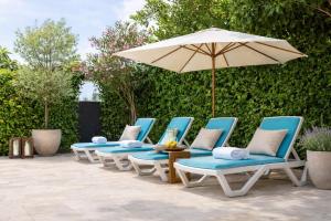 a group of chairs and an umbrella on a patio at Studio apartment with pool in Pula