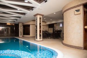 a swimming pool in a building with a dining room at Shaxzoda Elite Hotel in Samarkand