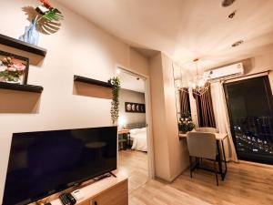 a living room with a large flat screen tv at Comfy Plum West Gate Condo 1 BR in Ban Bang Krabu