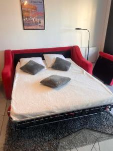 a bed with three pillows on it in a room at Appartement 200m plage Dinard in Dinard