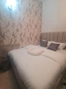 a bed with white sheets and pillows in a room at MAGLO bnb in Nakuru