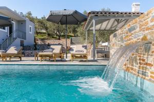 a swimming pool with a water fountain at Luxury VILLA RAFAEL in Skopelos Town