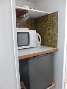 a small kitchen with a microwave on a counter at Meublé La Sergerie in Le Lavandou