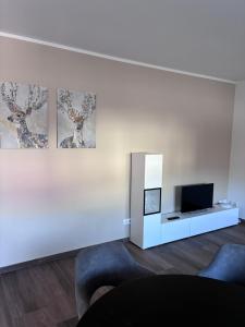 a living room with a couch and a tv on a wall at Hügelland Apartment in Elxenbach