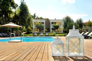 a villa with a swimming pool and a house at Sani Polyastron Hotel & Spa in Sani Beach