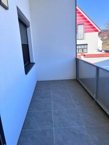 a balcony with a tile floor and a white wall at Hügelland Apartment in Elxenbach