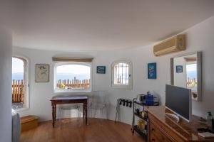 a living room with a desk and three windows at Meublé La Sergerie in Le Lavandou