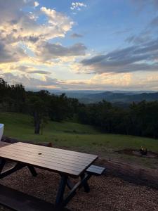 a wooden picnic table sitting on top of a field at Romantic Stargazing Getaway - Beyond Bubbles in Kanimbla +6 photos