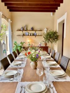 a long table with glasses and flowers on it at Villa Nekazabal in Sa Pobla
