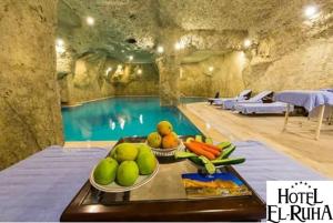 una piscina con una bandeja de frutas y verduras en una mesa en Elruha Hotel, en Sanlıurfa