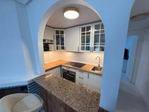 a kitchen with white cabinets and a counter top at Flamingo Apartman in Torrevieja