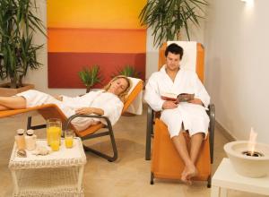 a man and woman sitting in chairs in a spa at Appartements Bergsonne in Westendorf