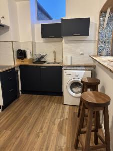a kitchen with a washing machine and two stools at Kadéraf in Cherbourg en Cotentin